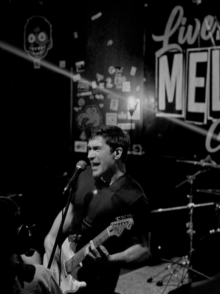 a member of the band horace pinker plays guitar during a performance in bloomington, Illinois
